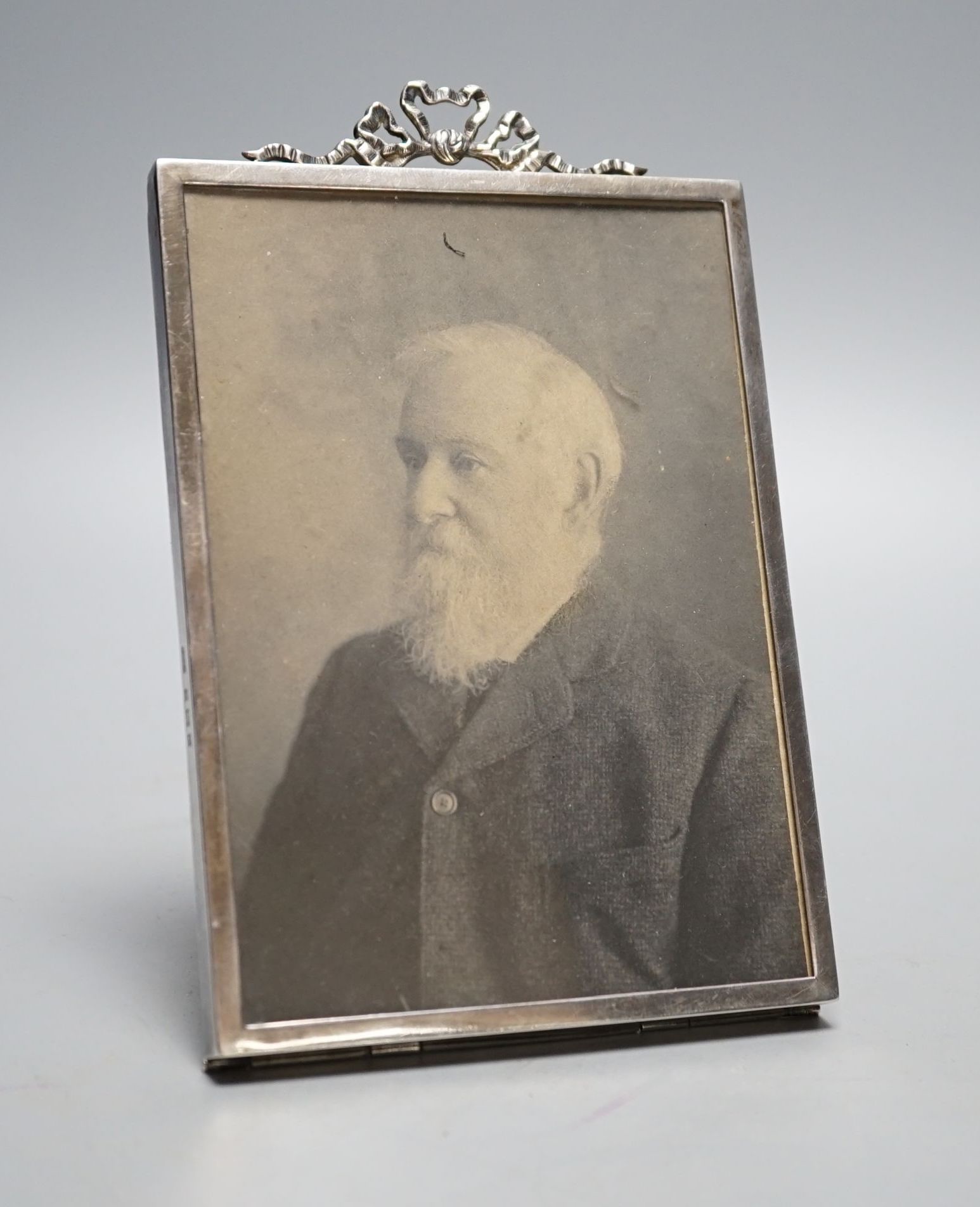 An Edwardian silver mounted photograph frame, with ribbon bow crest, Birmingham, 1902, overall 15.8cm.
